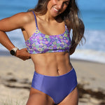 Woman wearing a floral purple bikini on a beach