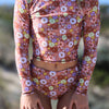 Floral patterned two-piece swimsuit with long sleeves on a blurred natural background