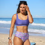 Woman in a purple bikini with floral pattern on a beach
