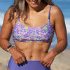 Woman wearing a colorful floral bikini top on a beach